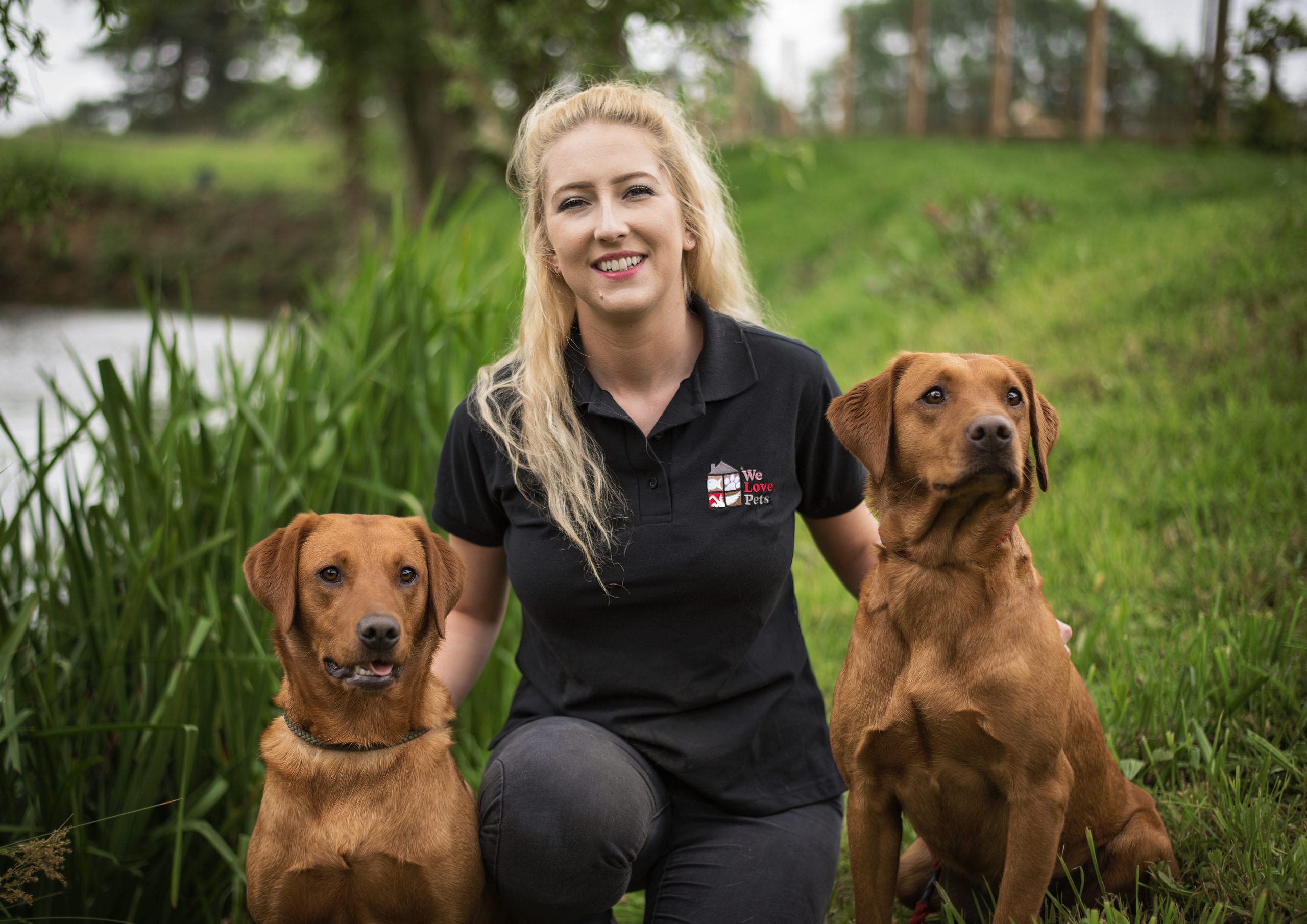 Elkie from We Love Pets Portsmouth sitting with two dogs