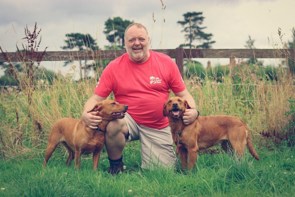 Jannes from We Love Pets Billericay kneeling with two dogs