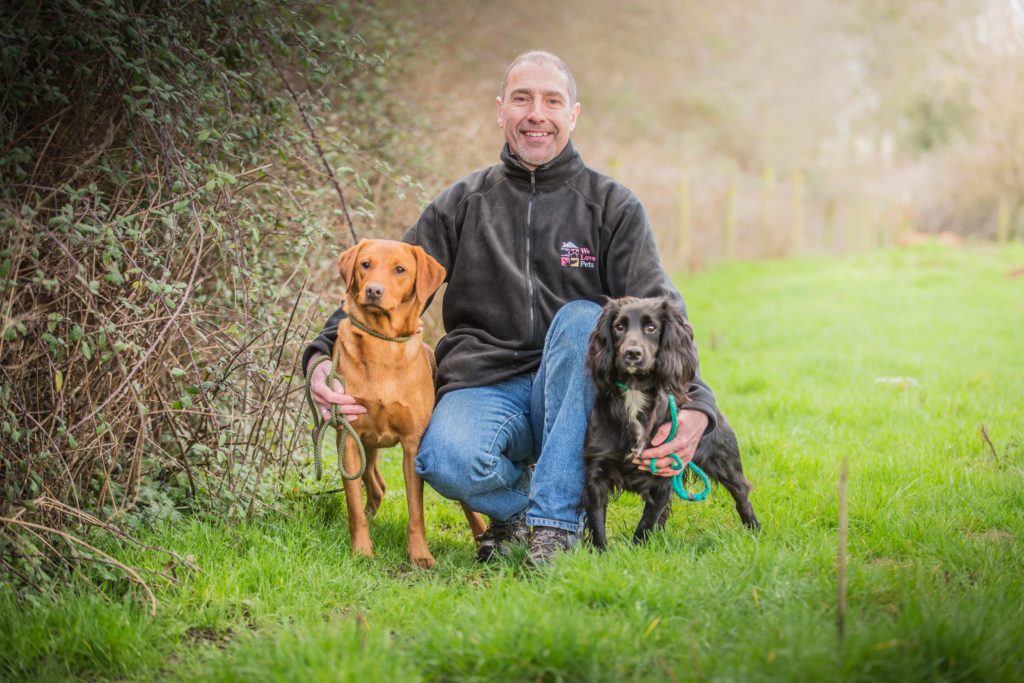 Andrew from We Love Pets Swindon holding two dogs