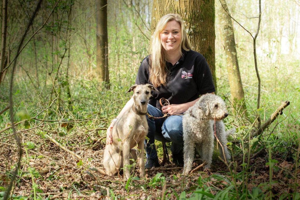 Emma from We Love Pets Farnborough sitting with two dogs
