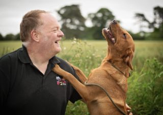Paul from We Love Pets Lytham laughing with a dog