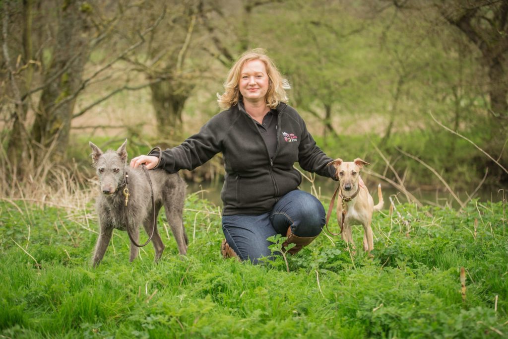 Sam from We Love Pets Twyford kneeling next to two dogs