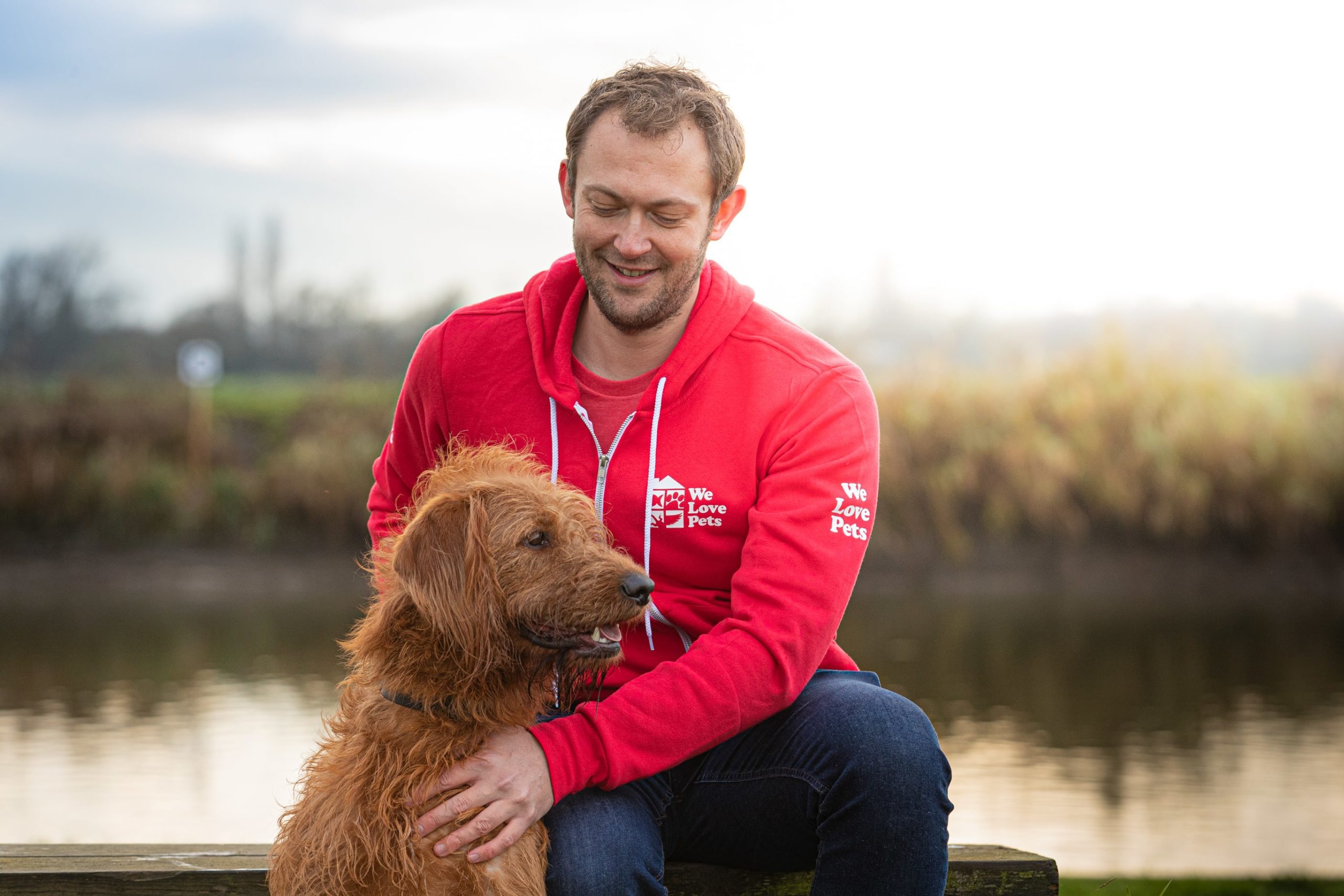 Jon from We Love Pets Newcastle sat holding a dog