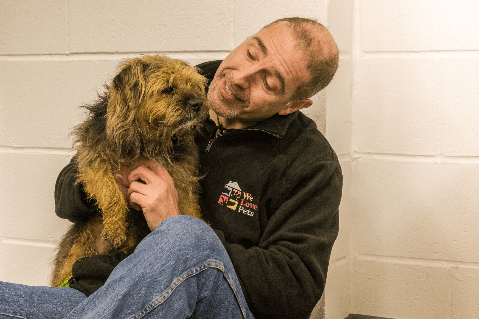 Man holding a dog in his lap