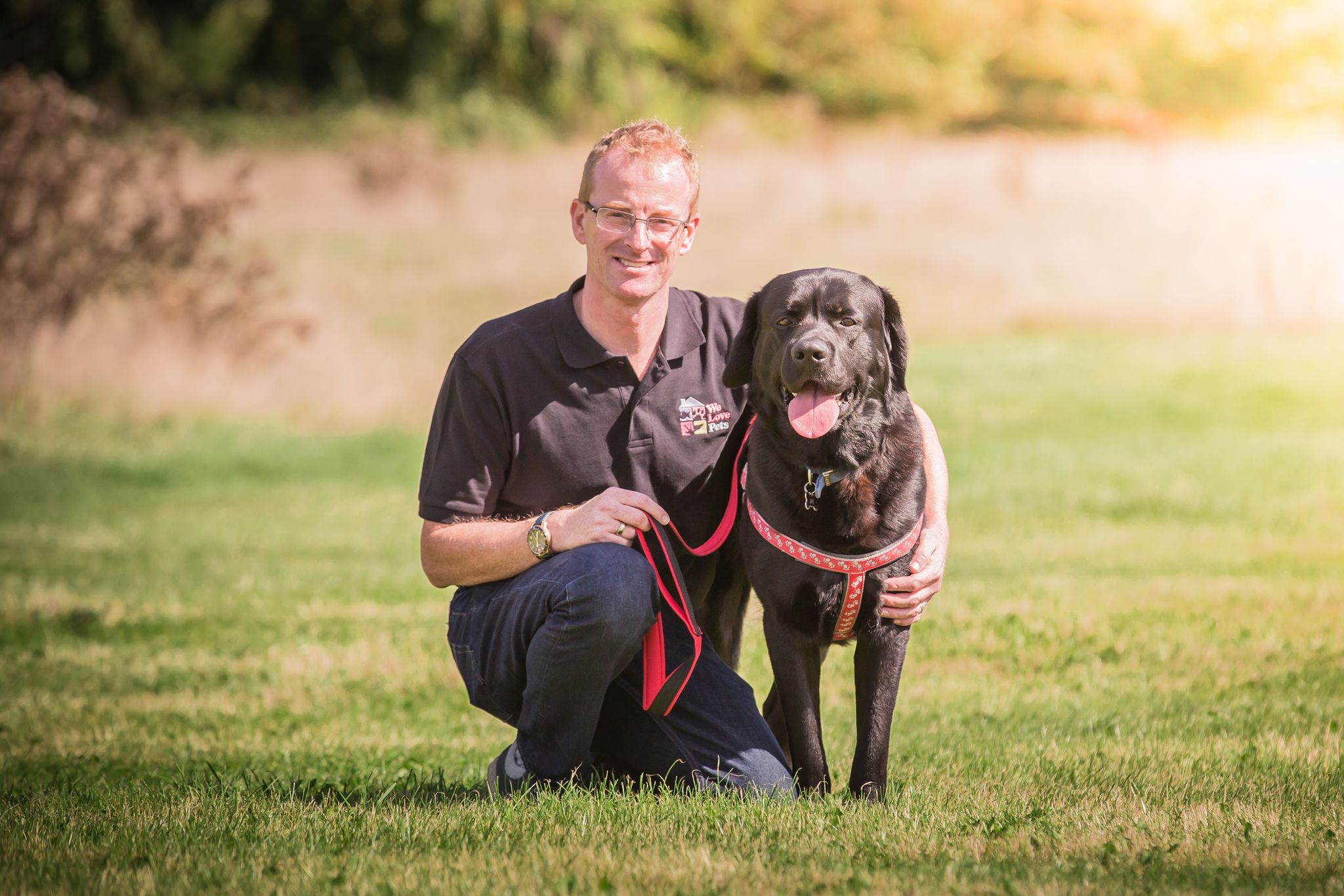 Man from We Love Pets Sleaford crouched down next to a dog