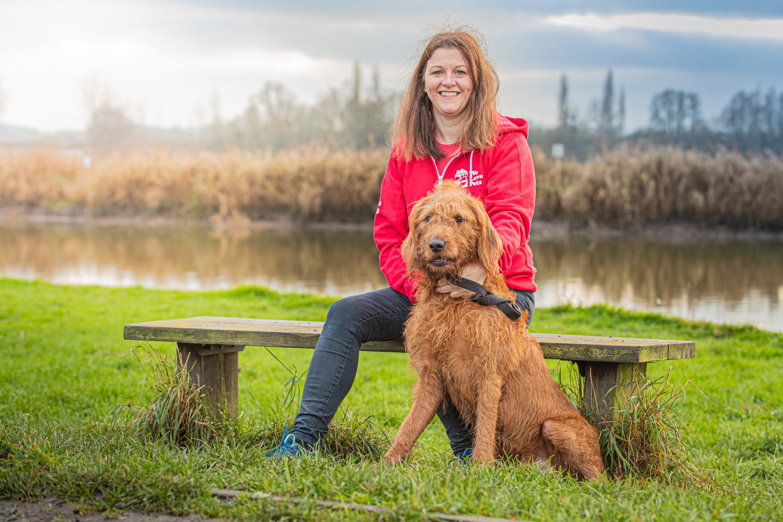 Woman sat on bench with dog