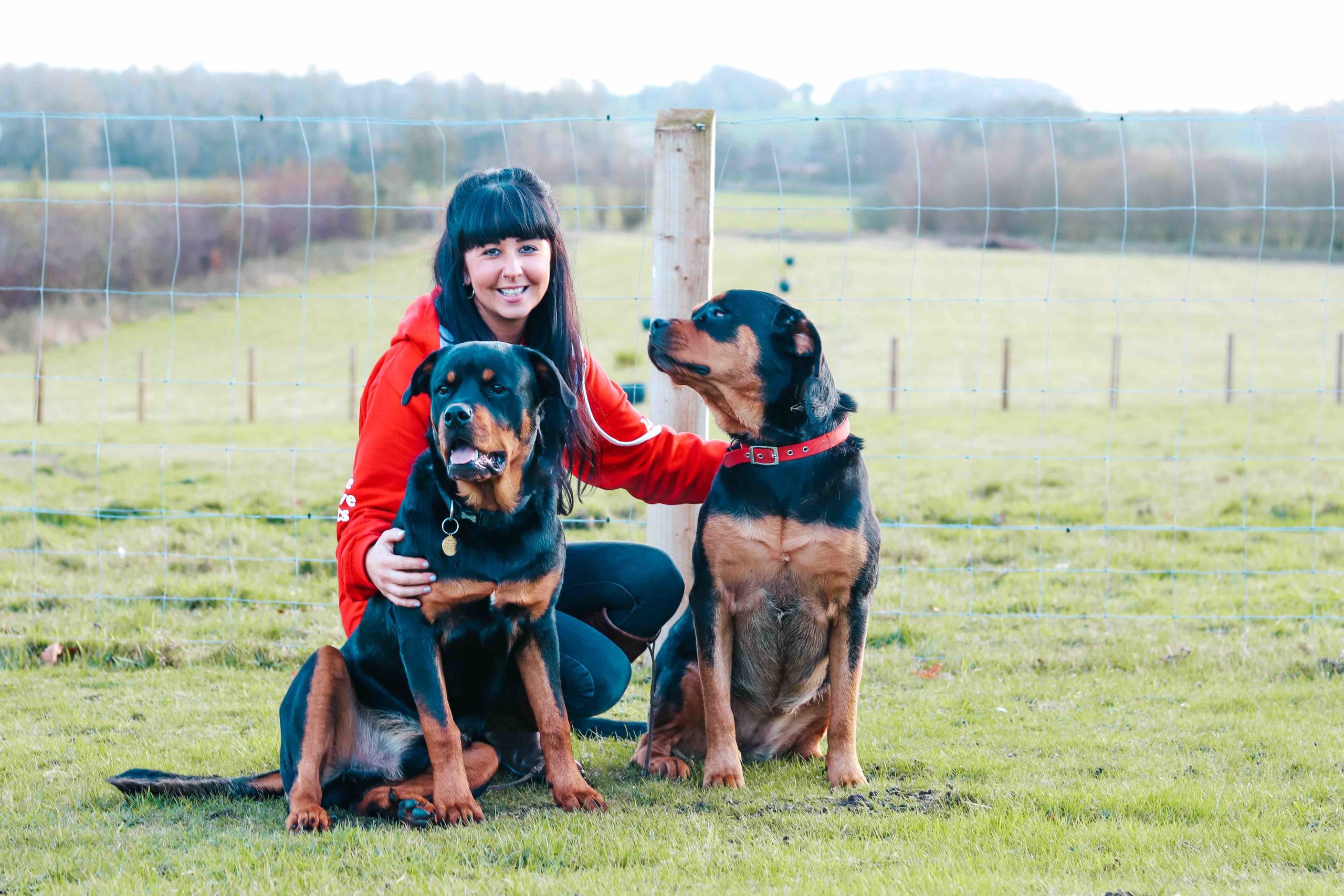 Danielle from We Love Pets kneeling with two sitting dogs