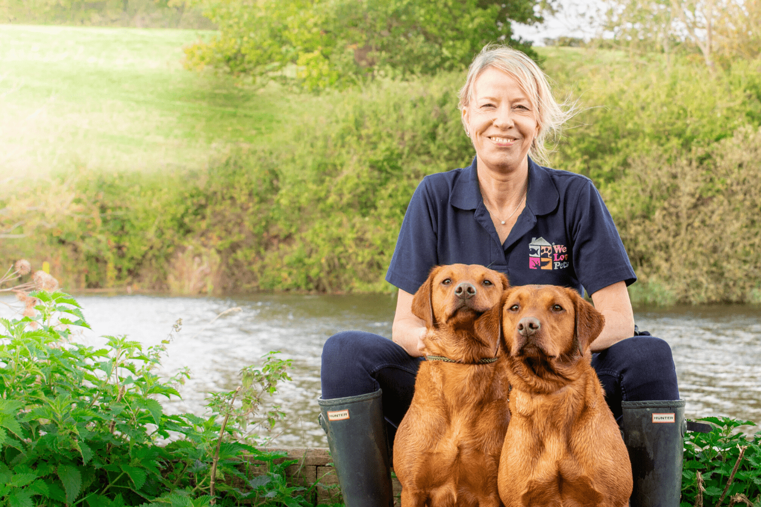 Woman from We Love Pets Guildford sat with two dogs in front