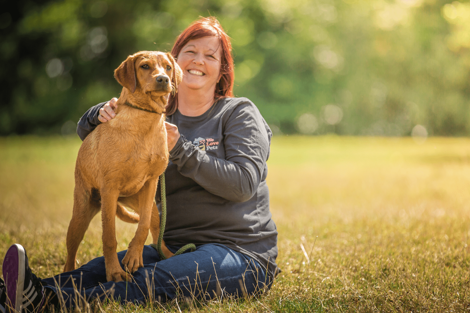 Woman sat with a dog standing in her lap