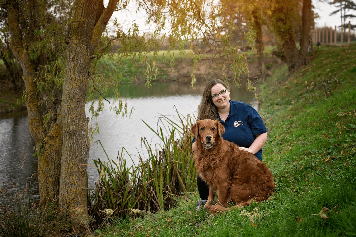 Woman sat down next to sitting dog