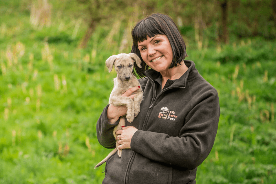 Woman smiling while holding a puppy