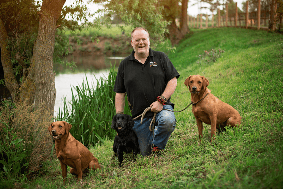 Happy man kneeling next to sat dogs