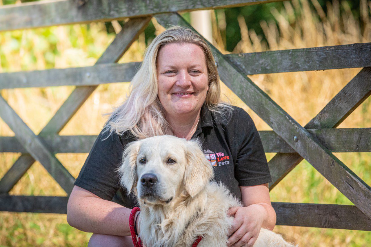 Dog walker Jo from We Love Pets Cranleigh crouched with a dog
