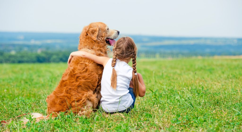 Young girl with arm around a dog