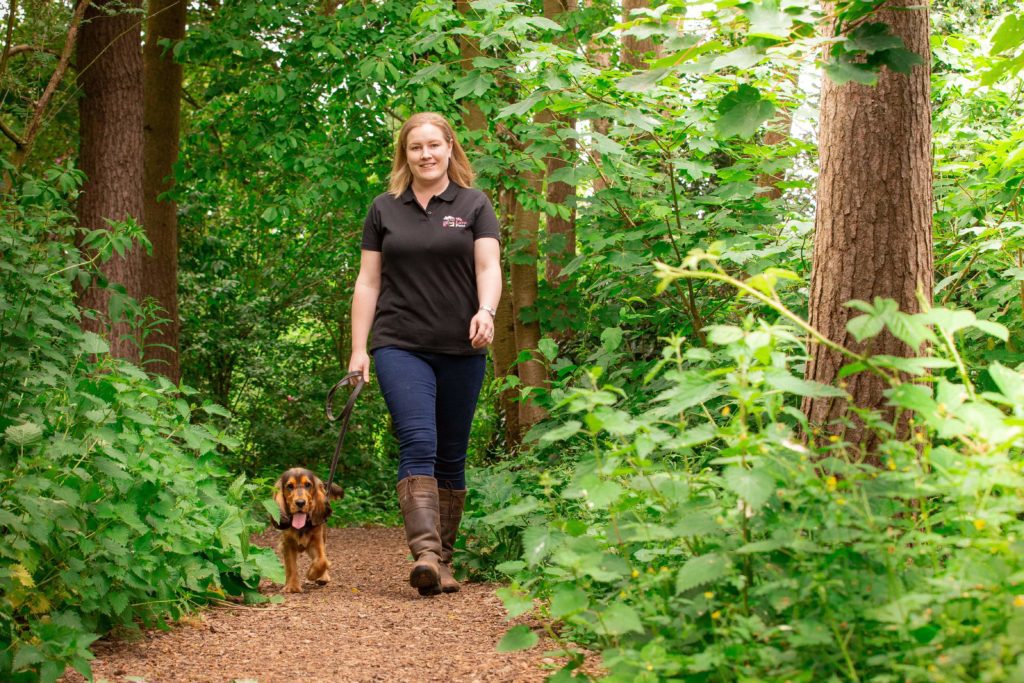 Woman and dog walking through woods